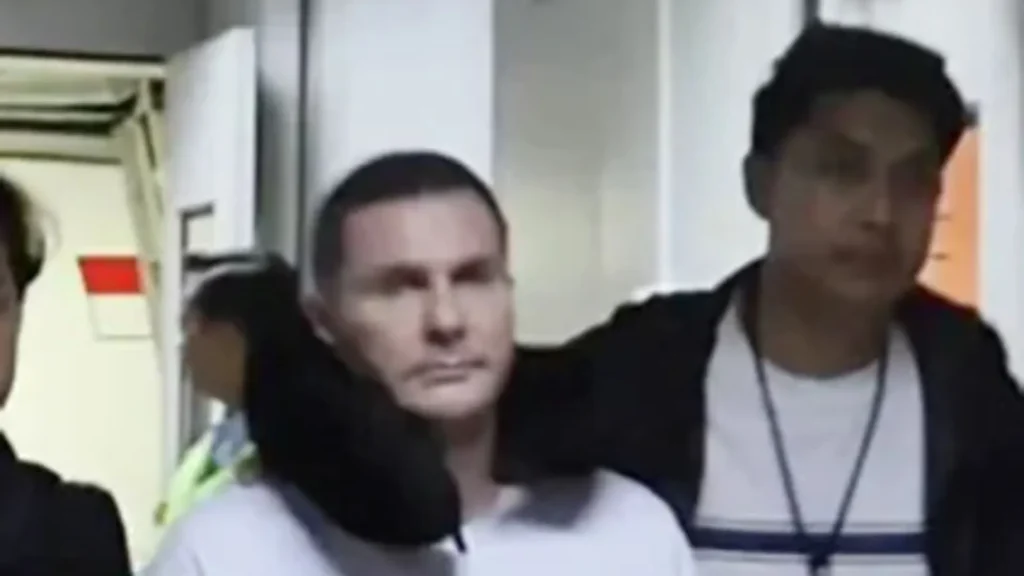 Rekaman terbaru memperlihatkan bos geng asal Skotlandia, Steven Lyons, digiring melintasi bandara setelah dideportasi dari Bali